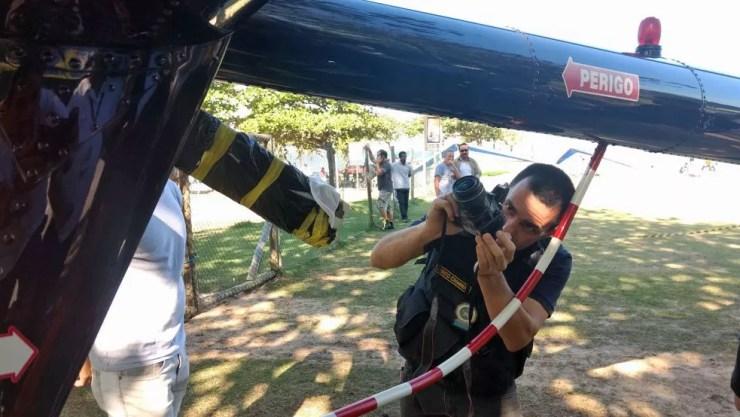 Perito fotografa helicóptero para analisar marcas que podem ser de tiro (Foto: Marcos Serra Lima/G1)