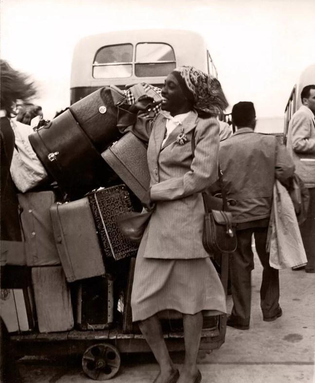 Melânia Luz, ao lado de várias malas, sorri no desembarque em Londres em 1948 — Foto: Chris Ware / Revista Fon Fon