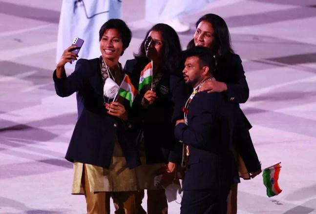 Atletas da Índia fazem selfie sem máscara durante desfile na cerimônia de abertura de Tóquio 2020 — Foto: REUTERS/Lucy Nicholson