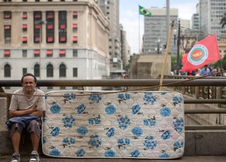 Um ativista do Movimento dos Trabalhadores Sem Teto se senta ao lado de seu colchão durante um protesto contra os cortes orçamentários do governo em programas de habitação de baixa renda em São Paulo — Foto:  Andre Penner/AP