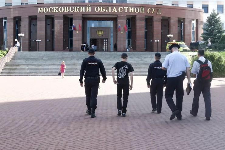 Policiais caminham em direção ao Tribunal Regional de Moscou, na Rússia, nesta terça-feira (1º) após réus tentarem roubar armas de segurança durante julgamento (Foto: Andrey Nikerichev/Moscow News Agency via AP)