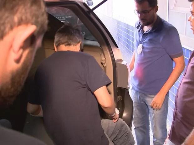 Cercado por curiosos e jornalistas no hospital, Hugo entra na viatura  (Foto: Reprodução / TV TEM)
