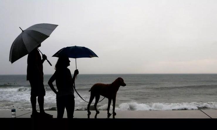 Casal e cão aguardam a chegada do furacão Willa, em Mazatlan, no México, na terça-feira (23) — Foto: Marco Ugarte/AP