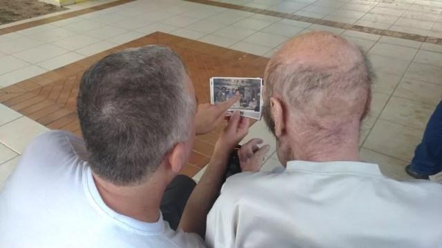 Michel e Juan relembram o passado por meio de fotografias (Foto: Matheus Fazolin/G1)