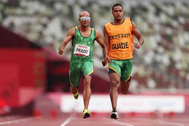 Lucas Prado e o atleta-guia Anderson Machado Santos nas eliminatórias dos 100m T11 nas Paralimpíadas Tóquio 2020 — Foto: Naomi Baker/Getty Images