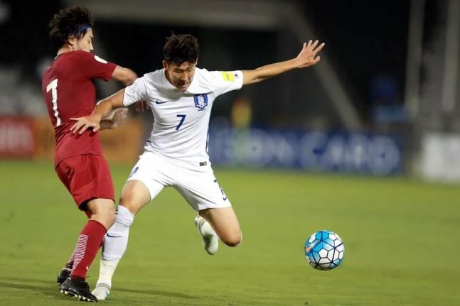 Rodrigo Tabata, em ação pela seleção do Catar, disputa bola com o coreano Son, do Tottenham — Foto: AFP
