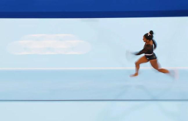 Simone Biles corre para saltar durante treino de pódio — Foto: Getty Images