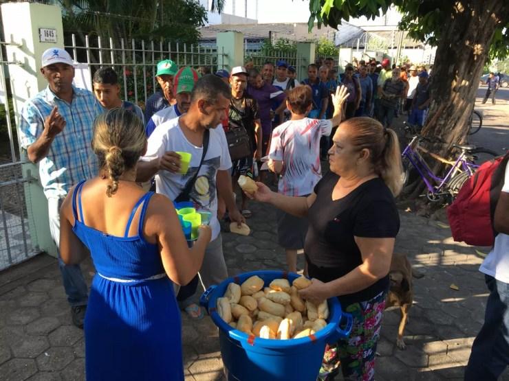Venezuelanos recebem pão e copo de suco servido por missionárias católicas no Centro de Boa Vista — Foto: Emily Costa/G1 RR