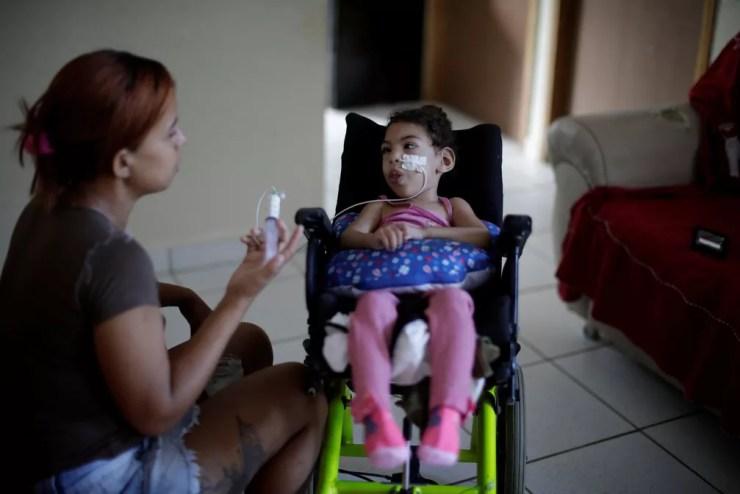 Rosana Vieira Alves, de 28 anos, alimenta a filha de dois anos Luana Vieira, que nasceu com microcefalia — Foto: Ueslei Marcelino/Reuters
