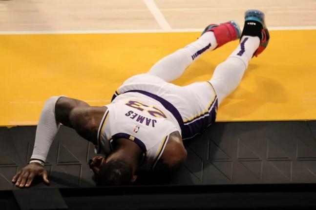 LeBron James cai no chão após torcer o tornozelo em Lakers x Hawks — Foto: Michael Owens/Getty Images