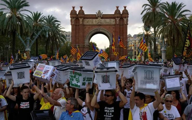 Manifestantes pró-independência exibem urnas usadas na votação pela separação da Catalunha, em frente ao Arco do Triunfo, em Barcelona, em protesto realizado um ano após referendo, na segunda-feira (1) — Foto: AP Photo/Daniel Cole