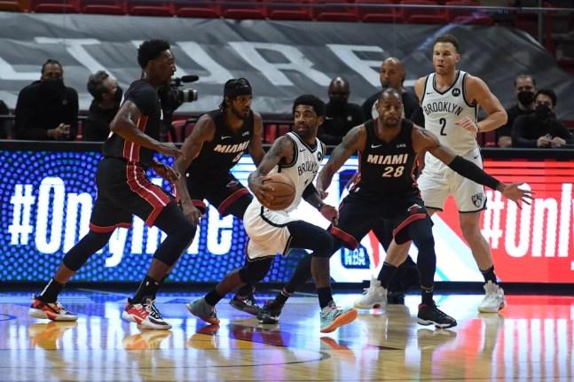 Kyrie Irving (camisa branca, 11) se vê cercado por defensores do Heat: marcação do Miami criou problemas para Brooklyn — Foto: Carlos Goldman/NBAE via Getty Images