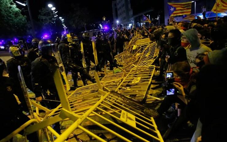 Manifestantes pró-independência derrubam barreiras que os separavam de policiais durante protesto em Girona, realizado um ano após referendo de separação da Catalunha, na segunda-feira (1) — Foto: AP Photo/Manu Fernandez