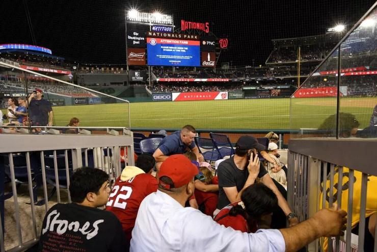Torcedores se escondem em estádio durante tiroteio em Washington, nos EUA, em 17 de julho de 2021 — Foto: Nick Wass/AP