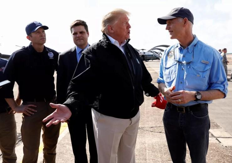 Donald Trump conversa com o governador da Flórida Rick Scott ao chegar à base Eglin, da Força Aérea, a caminho de visitar a região destruída pelo furacão Michael — Foto: Reuters/Kevin Lamarque