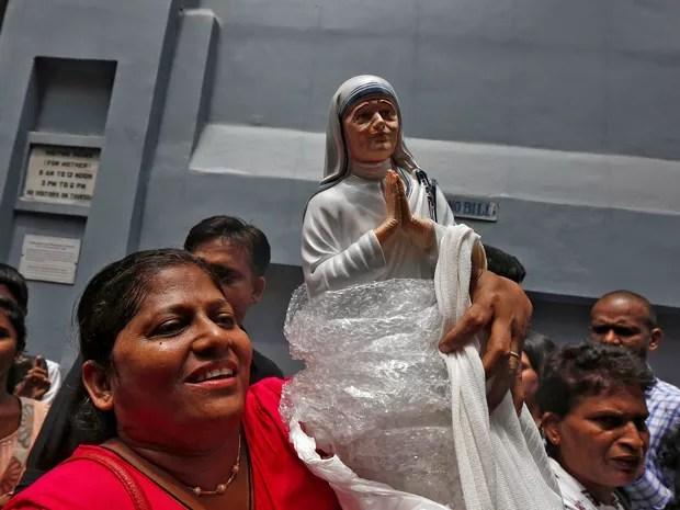 Fiel ergue estátua da Madre Teresa do lado de fora de uma filial das Missionárias da Caridade em Calcutá, na Índia, enquanto ela era canonizada neste domingo (4) em cerimônia no Vaticano (Foto: REUTERS/Rupak De Chowdhuri)