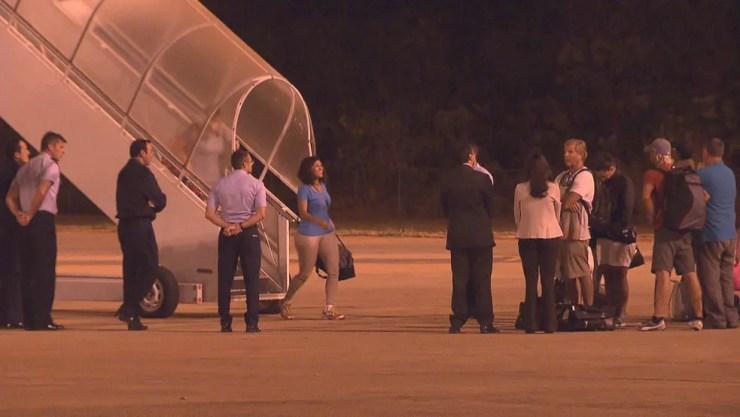 Passageiros resgatados desembarcando na Base Aérea (Foto: TV Globo/Reprodução)