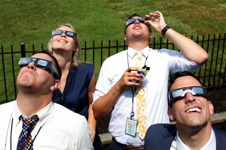 Grupo de jornalistas assiste ao eclipse dentro da Casa Branca  (Foto: Yuri Gripas/Reuters)