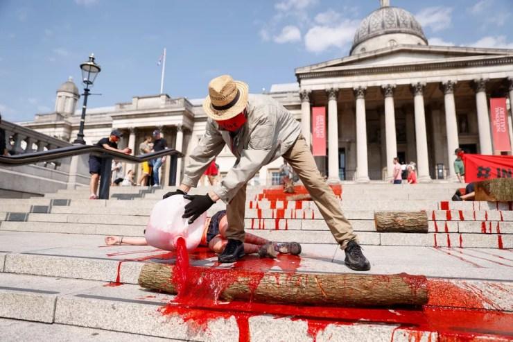 9 de agosto - Ativista derrama sangue falso em frente à National Gallery, em Londres, durante protesto contra o impacto do coronavírus (Covid-19) nas comunidades indígenas do Brasil — Foto: John Sibley/Reuters