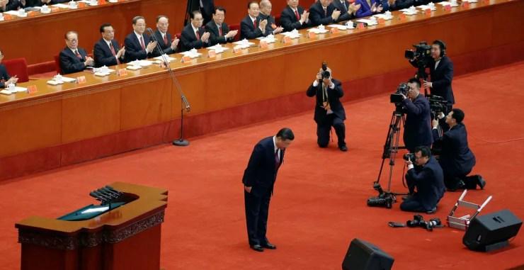 Xi Jinping se curva à plateia durante o congresso do PC chinês (Foto: Jason Lee/Reuters)