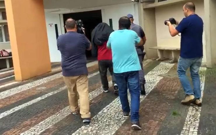 Um dos presos da 3ª fase da Operação Ouro Verde chega ao Ministério Público — Foto: Cristina Maia/EPTV