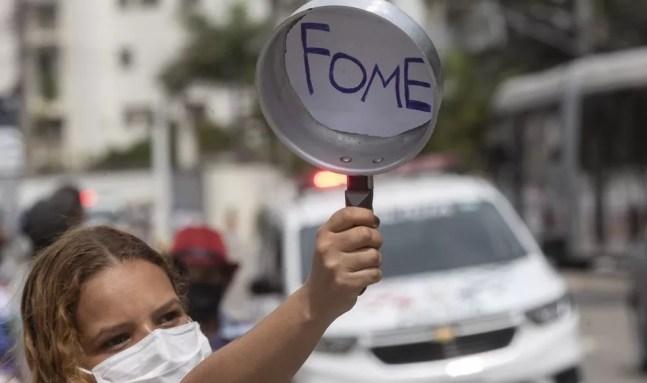 Moradora de Paraisópolis mostra panela vazia durante protesto em São Paulo nesta segunda-feira (5) — Foto: André Penner/AP Photo
