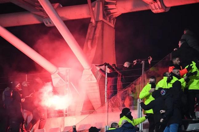 Torcida do Lyon acende sinalizadores e atira contra torcedores do Paris FC, no início da confusão em jogo da Copa da França — Foto: Bertrand Guay/AFP