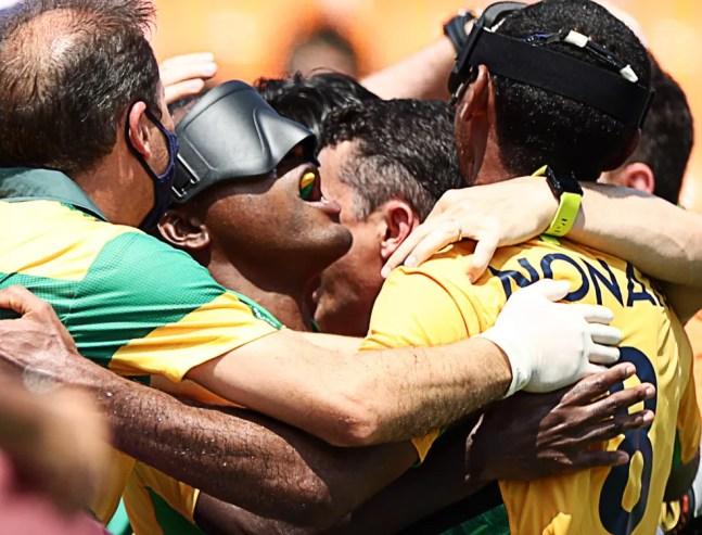 Jogadores do Brasil se abraçam para comemorar um gol contra o Japão no futebol de 5 — Foto: REUTERS/Lisi Niesner