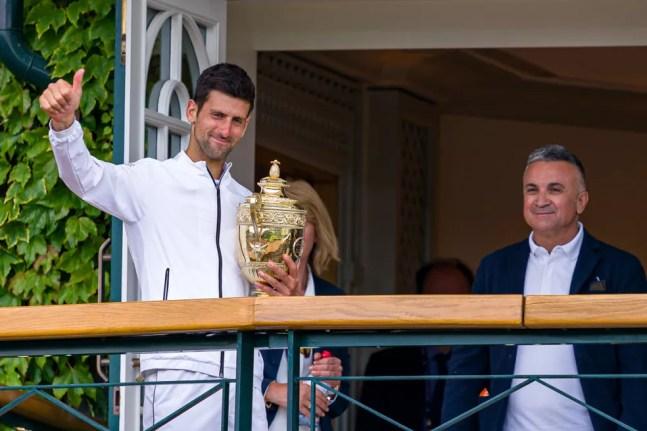 Djokovic com o troféu de Wimbledon 2021 ao lado de seu pai, Srdjan — Foto: Andy Cheung / Getty Images