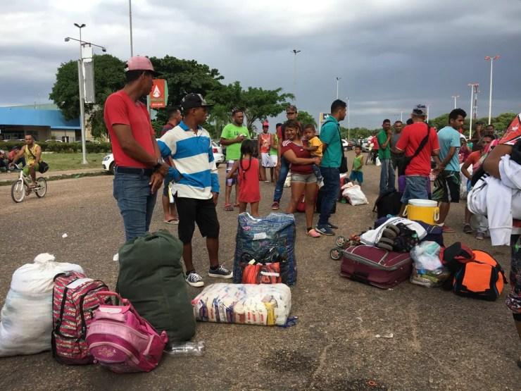 Levando comida e remédios, venezuelanos fazem fila para embarcar em ônibus com destino ao país natal  — Foto: Emily Costa/G1 RR
