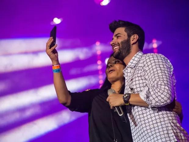 Ídolo sertanejo, Gusttavo Lima faz selfie com fã no palco da Festa de Barretos (Foto: Mateus Rigola/G1)