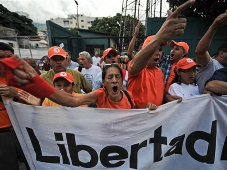 Jornalistas e trabalhadores de mídia fazem protesto pelas 32 rádios e duas TVs fechadas pelo governo venezuelano há um ano, em Caracas — Foto: Miguel Gutierrez / AFP