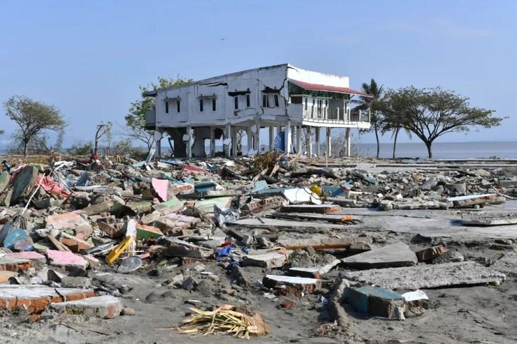 Prédio ficou danificado em meio aos destroços em uma vila de pescadores em Palu, na Indonésia, após região ter sido atingida por terremoto e tsunami  — Foto: Adek Berry / AFP
