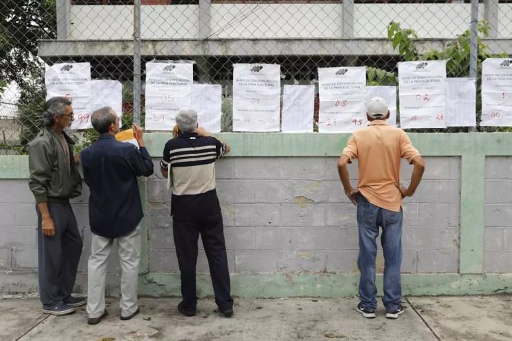 Eleitores conferem salas de votação nas eleições deste domingo (10) na Venezuela (Foto: Carlos Jasso/Reuters)