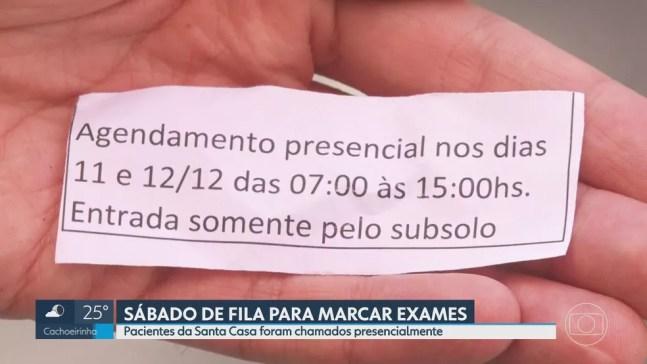 Papel distribuído pela Santa Casa para orientar sobre a marcação de consultas e exames neste fim de semana. — Foto: Reprodução/TV Globo
