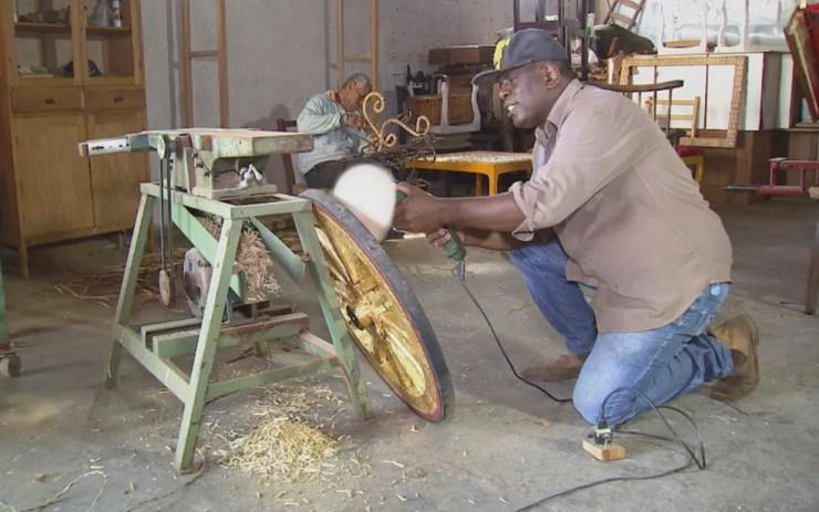 Artesão arruma a roda que conseguiu em outro Estado para montar a carruagem (Foto: Reprodução/TV TEM)